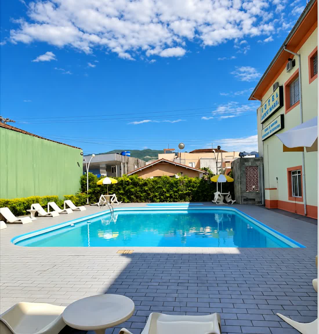 Piscina ao ar livre e terraço em um dia de sol no Hotel Guanabara Caraguatatuba
